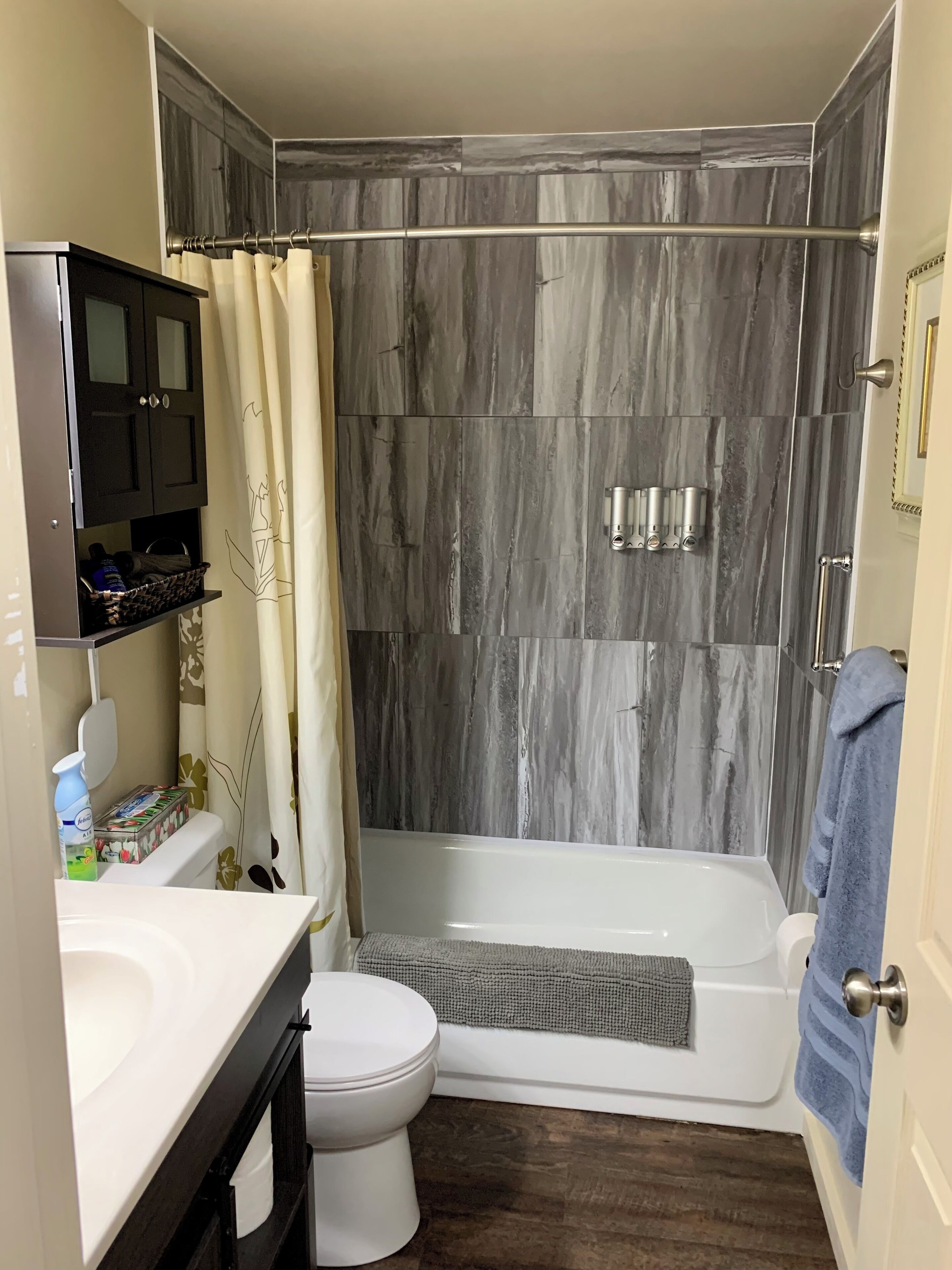 Une salle de bain avec douche, toilettes et lavabo.