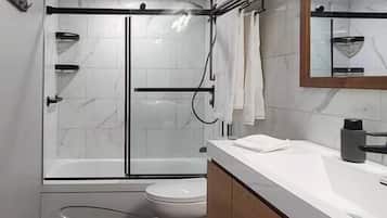 Bathtub, hair dryer, towels, toilet paper