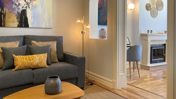 A modern living room with a grey sofa, a wooden coffee table, and a painting on the wall. - Housing Sol by Sharing Co (Madrid)