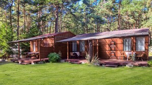 A cabin with a porch and a dining area, surrounded by a forest. - 1 bedroom awesome apartment in Pogorzelica (Pogorzelica)