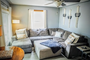 A modern living room with a sectional sofa, a coffee table, and wall art. - 4-bedroom in-ground pool 10 minutes to Downtown Grand Rapids and GRR Airport (Grand Rapids)