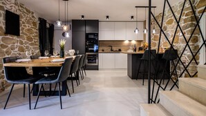 A modern kitchen with a central island, dark cabinetry, and pendant lighting.