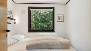 A bedroom with a bed, a window with a view of trees, and a framed picture on the wall. - 3 bedroom stunning home in Hasle (Hasle)