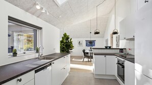 Een moderne keuken met witte kastjes, een zwart aanrecht en een ingebouwde oven.