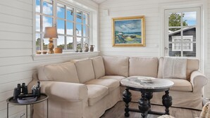 A corner living room with a beige sectional sofa, a round table, and a painting on the wall. - 3 bedroom stunning home in Hejls (Hejls)