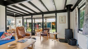 A spacious living area with a high ceiling, wooden beams, a large window, and a fireplace. - Gorgeous home in Gørlev with WiFi (Gørlev)
