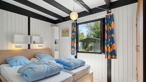 A bedroom with a bed, bedside tables, a window with curtains, and a view of the outside. - Gorgeous home in Gørlev with WiFi (Gørlev)