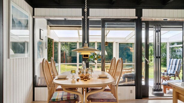 A dining area with a round table, wooden chairs, and a pendant lamp. - Gorgeous home in Gørlev with WiFi (Gørlev)