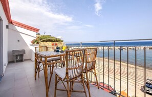 A balcony with a table and chairs, a small sink, and a view of the sea. - Beautiful home in Trappeto with WiFi (Trappeto)