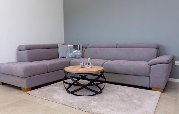 A modern living room with a grey sofa, a round wooden coffee table, and a fluffy rug. - Beach front home in Kastel Novi (Kastel Novi)