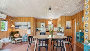 Un intérieur chaleureux en bois, comprenant un coin repas, une cuisine et un espace salon confortable.