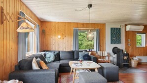 Un salon moderne avec un canapé d’angle, une petite table et une cheminée.
