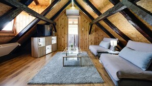 A cozy attic bedroom with a wooden ceiling, a glass table, a sofa, and a TV. - Gorgeous home in Duga Resa with WiFi (Duga Resa)