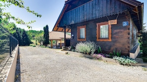 A rustic wooden house with a sloped roof, a porch, and a gravel driveway. - Gorgeous home in Duga Resa with WiFi (Duga Resa)