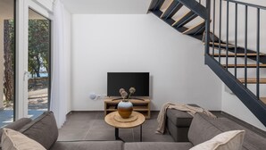A modern living room with a sofa, a coffee table, a TV, and a staircase. - Gorgeous home in Kraljevica with house sea view (Kraljevica)