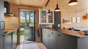 A modern kitchen with a wooden ceiling, built-in cabinets, and pendant lighting. - Awesome home in Saltum with WiFi (Saltum)