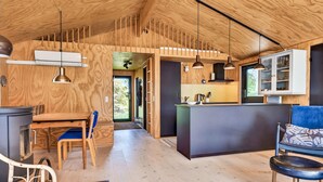A compact wooden interior with a dining area, kitchen, and seating space. - Awesome home in Saltum with WiFi (Saltum)
