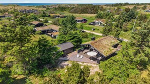 A residential area with multiple houses, some with green roofs, surrounded by trees and a view of the sea. - Awesome home in Saltum with WiFi (Saltum)