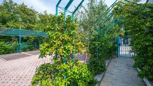 A covered walkway with a metal frame and a gated entrance.