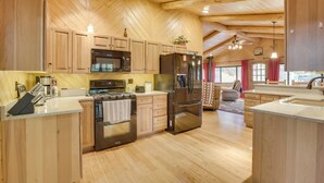 Una cocina amplia con gabinetes de madera, un refrigerador de acero inoxidable y una isla grande con un lavamanos.