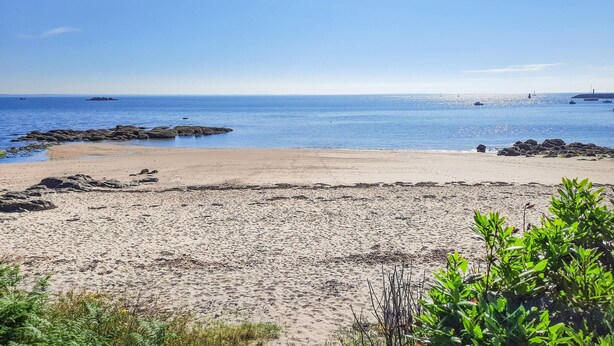 A beach with clear blue water, rocky outcrops, and sparse vegetation. - 4 bedroom pet friendly home in Quiberon (Quiberon)