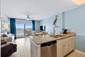 Relax in this ocean-view living room with a sofa, chairs, and flat-screen TV.
