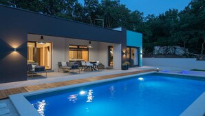 A modern house with a swimming pool, outdoor seating, and a well-lit patio area. - Awesome home in Krsan with sauna (Krsan)