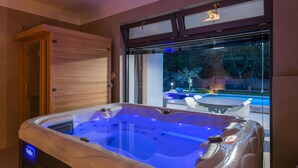 A hot tub with a view of a backyard and a wooden door. - Awesome home in Krsan with sauna (Krsan)