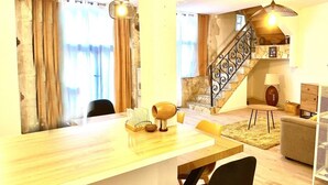 Un salon moderne avec une table à manger en bois, un escalier et un coin salon confortable.