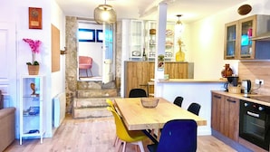 Une cuisine moderne avec une table à manger en bois, des chaises et un four encastré.