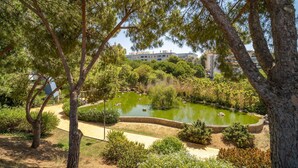 A park with a pond, surrounded by trees and greenery, with buildings in the background. - Stunning home in Marbella with WiFi (Marbella)
