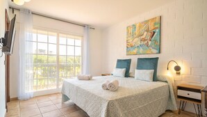 A hotel room with a large bed, a painting on the wall, a window with curtains, and a bedside table with a lamp. - Stunning home in Marbella with WiFi (Marbella)
