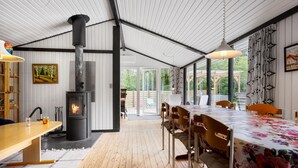 A spacious dining area with a wooden table and chairs, a large window, and a view of the outdoors. - Nice home in Højslev with kitchen (Højslev)