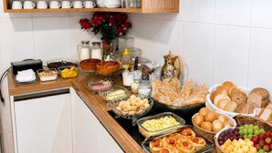 A buffet spread with various food items and glassware. - Casa hotel Piracicaba  (Piracicaba)