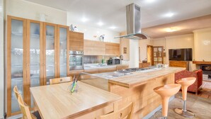 Uma cozinha moderna com armários de madeira, uma ilha central e um forno embutido.