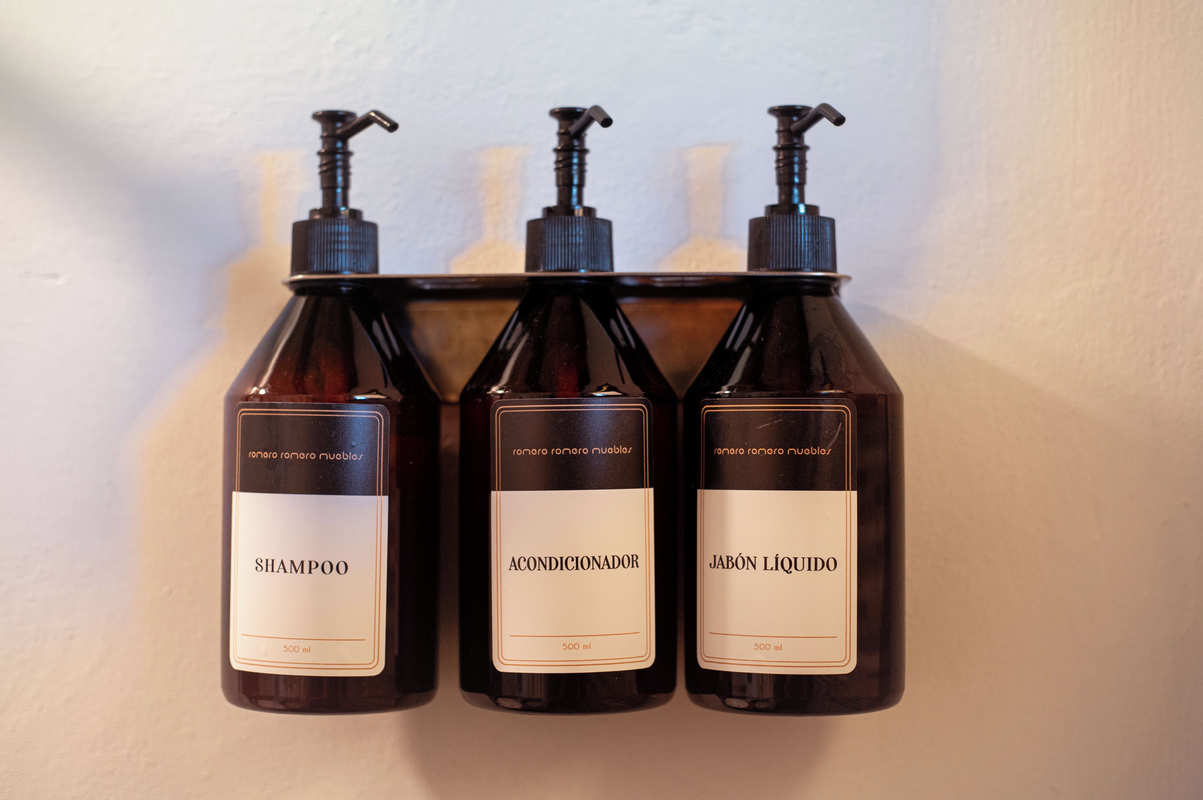 Three bottles of liquid with pumps, labeled as shampoo, conditioner, and liquid soap, each with a volume of 500 ml.