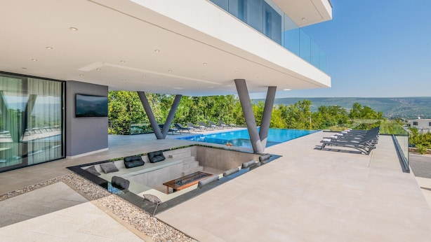 Uma área de piscina ao ar livre moderna com vista para a paisagem.