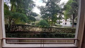 Un balcone con vista su un giardino curato e edifici residenziali.