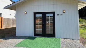A small, single-story building with a black door and a white exterior. - Modern studio in MarysVille – A Forest Haven (Marysville)