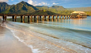 A pier extending into calm waters with mountains in the background. - STYLE & SPACE - YOUR NORTH SHORE ESCAPE. Minutes from Hanalei & Beaches. (Princeville)