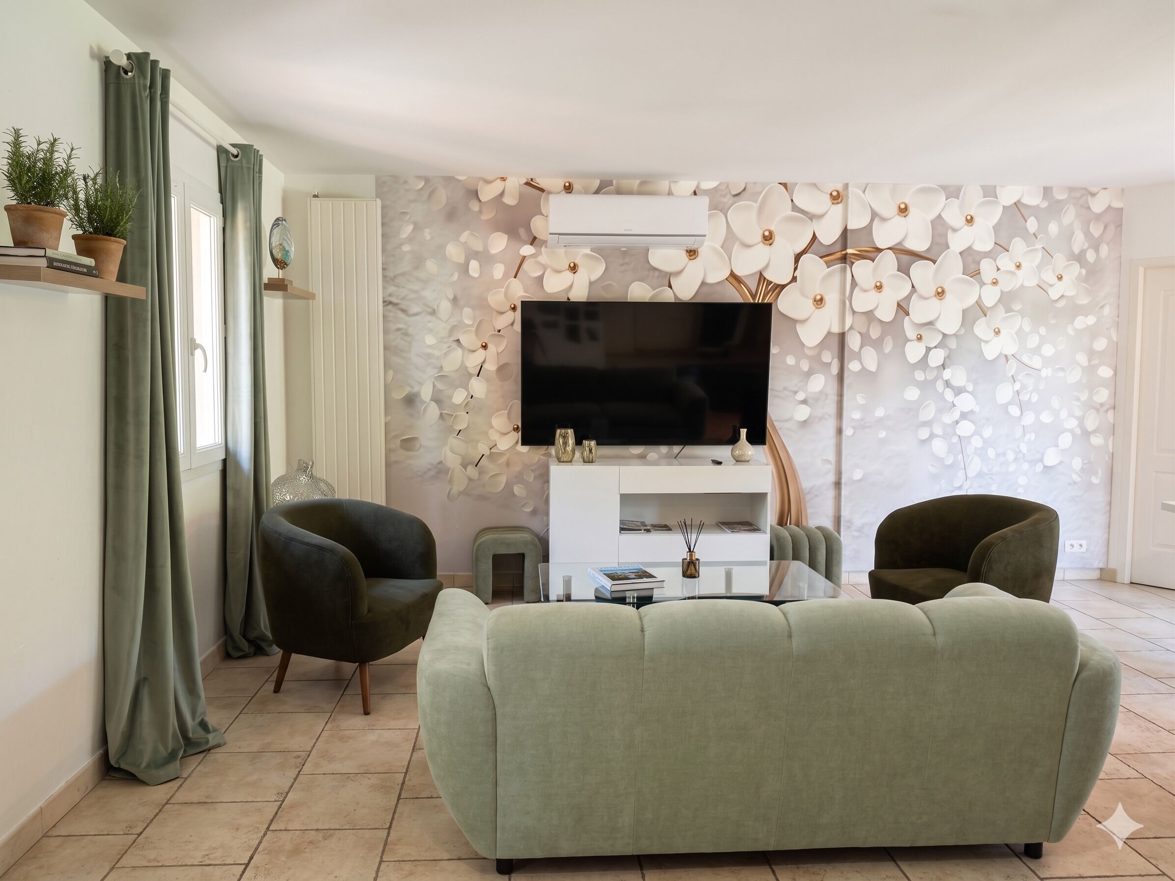 Een woonkamer met een bank, twee fauteuils, een televisie en een decoratieve wand.