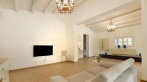 A spacious living room with a flat-screen TV, two chairs, a sofa, and a dining area with a table and chairs. - Stunning home in Menfi (Menfi)