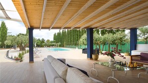 A covered outdoor area with a pool, a sofa, and a table with chess pieces. - Stunning home in Menfi (Menfi)