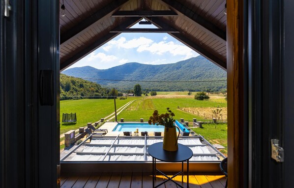 Relax on the deck with a view of the valley, pool, and distant mountains.