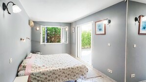 A bedroom with a bed, a window, and wall-mounted lights.