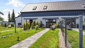 A modern two-story house with a metal roof, a covered patio, and a fenced garden area. - Nice home in Stare Sady with WiFi (Stare Sady)