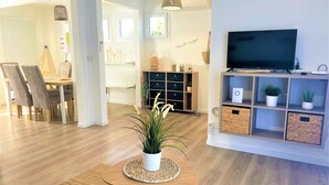 Un salon moderne avec un téléviseur, des meubles en bois et une plante en pot.