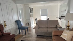 A living room with a sofa, armchairs, a rug, and a lamp. - The HoneyComb - Blocks from Historic Waterfront (Beaufort)