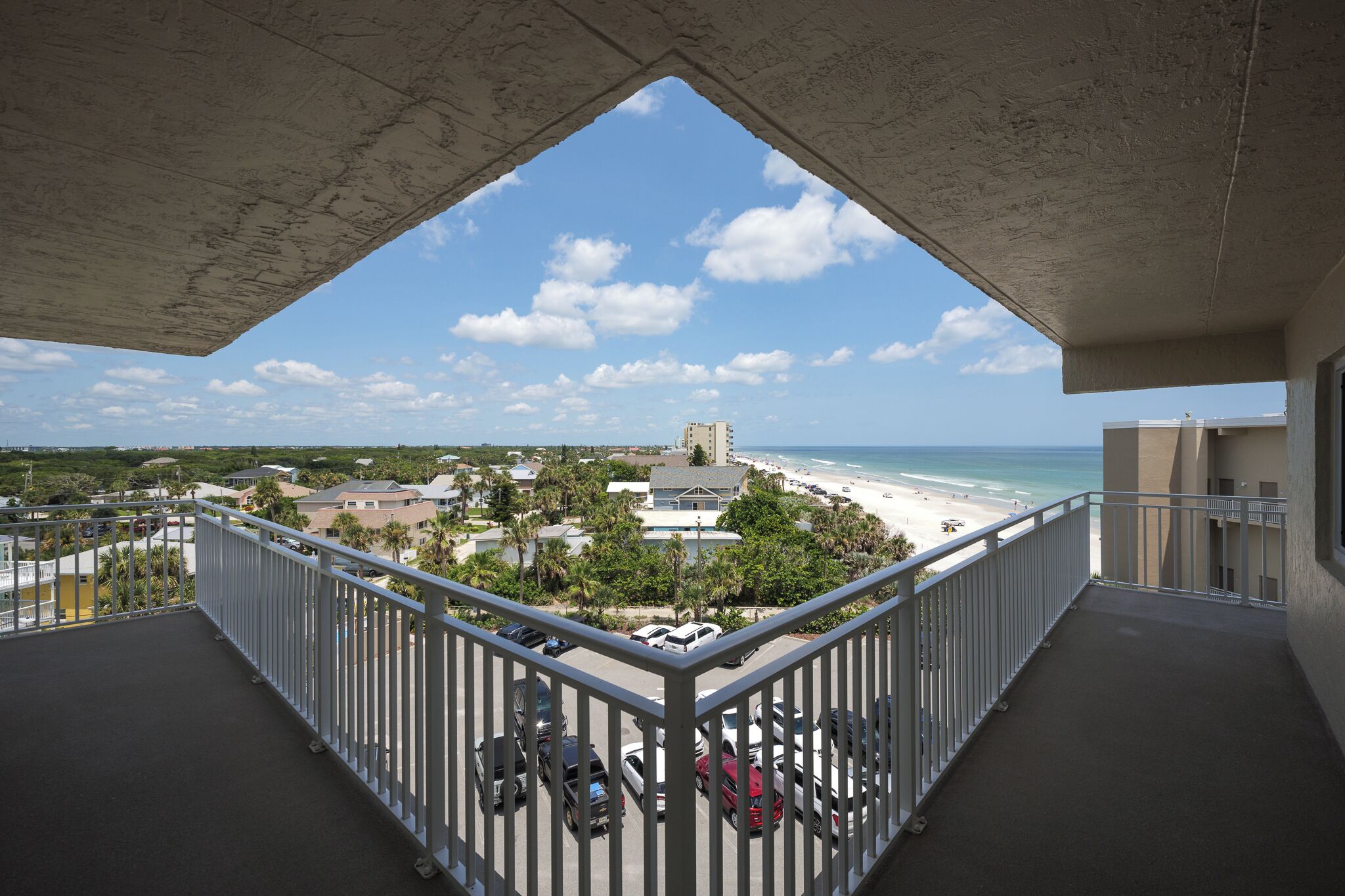 Un balcon avec vue sur une plage et l’océan.