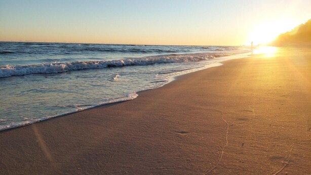 A beach with waves and a sunset. - Gorgeous apartment in Darlówko with WiFi (Darlówko)